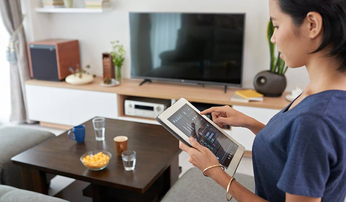 Woman using tablet with smart home apps to control security system