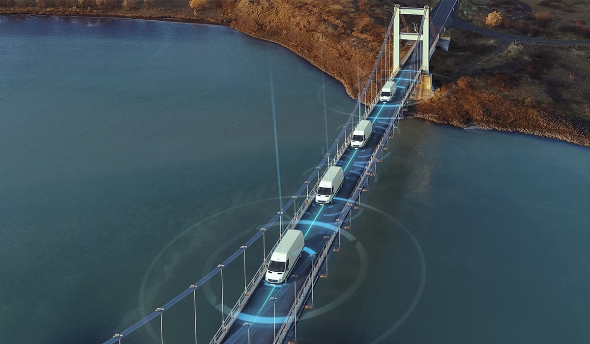 Big White vans crossing bridge over water with tech like circles around them to indicate tracking