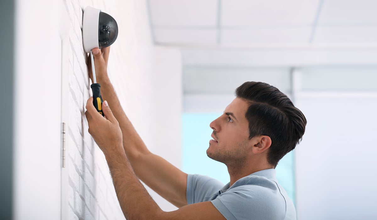 Security Worker installing motion detection camera