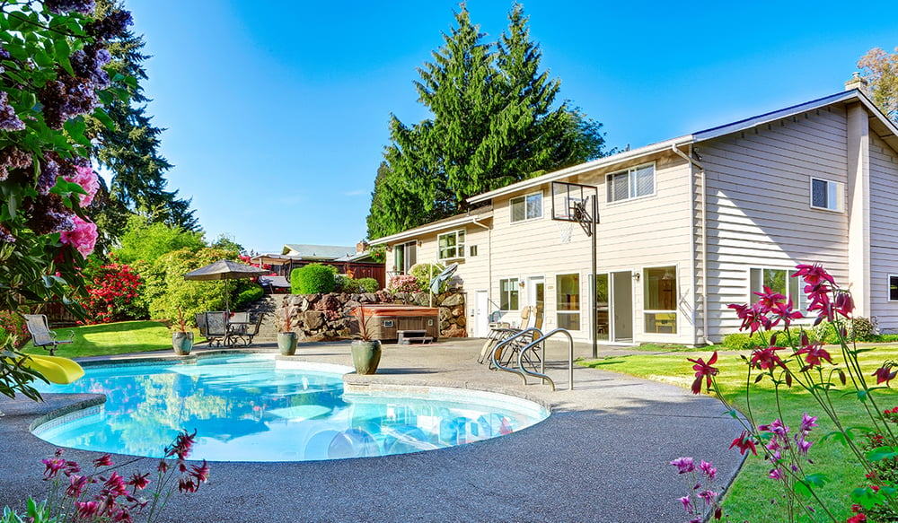 Summer home backyard with pool and basketball hoop