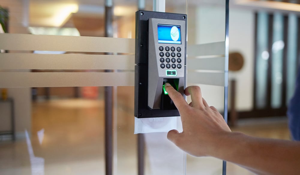 A closeup of a person using a keypad entry system to get into a commercial building