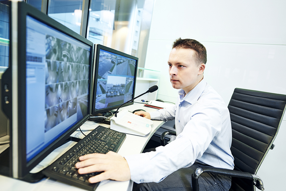 Security worker looking intensely at monitors