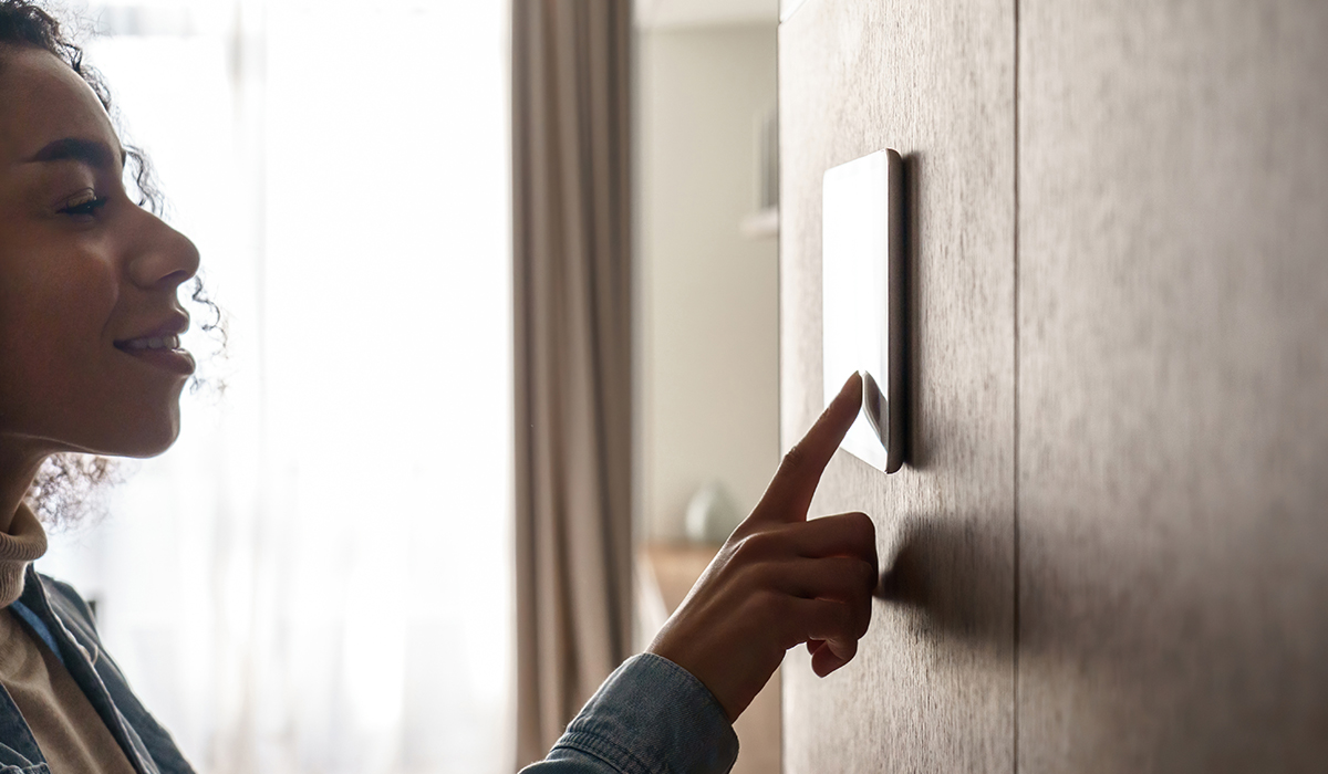 African american woman using smart security screen in house