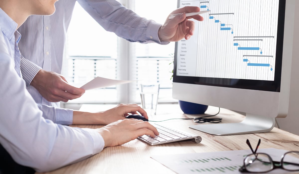 Coworkers looking at analytics on computer screen