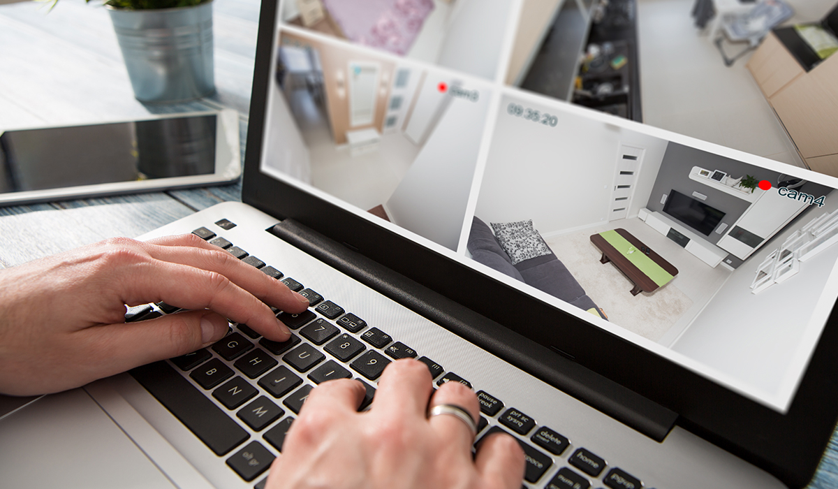 Man typing on computer looking at Home Security Camera Feed