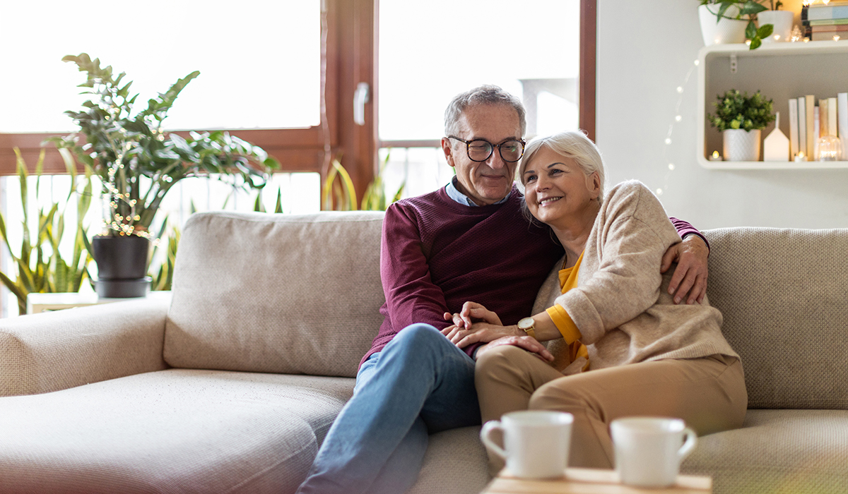 Senior couple embracing on couch